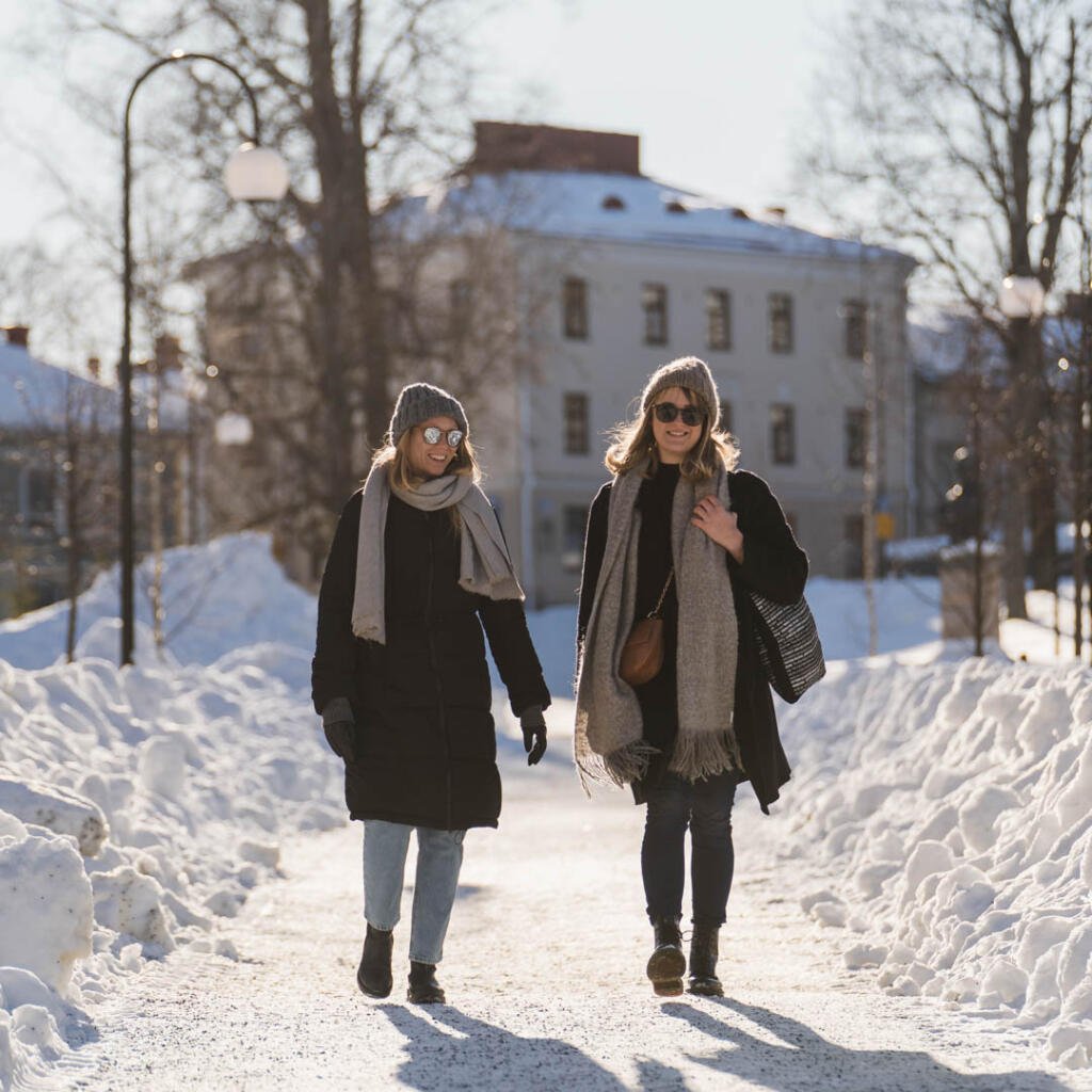 Kuopion keskusta talvella, ystävykset kävelemässä Snellmaninpuistossa